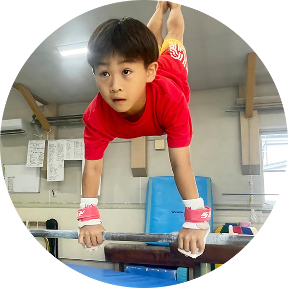 鉄棒の練習をする少年